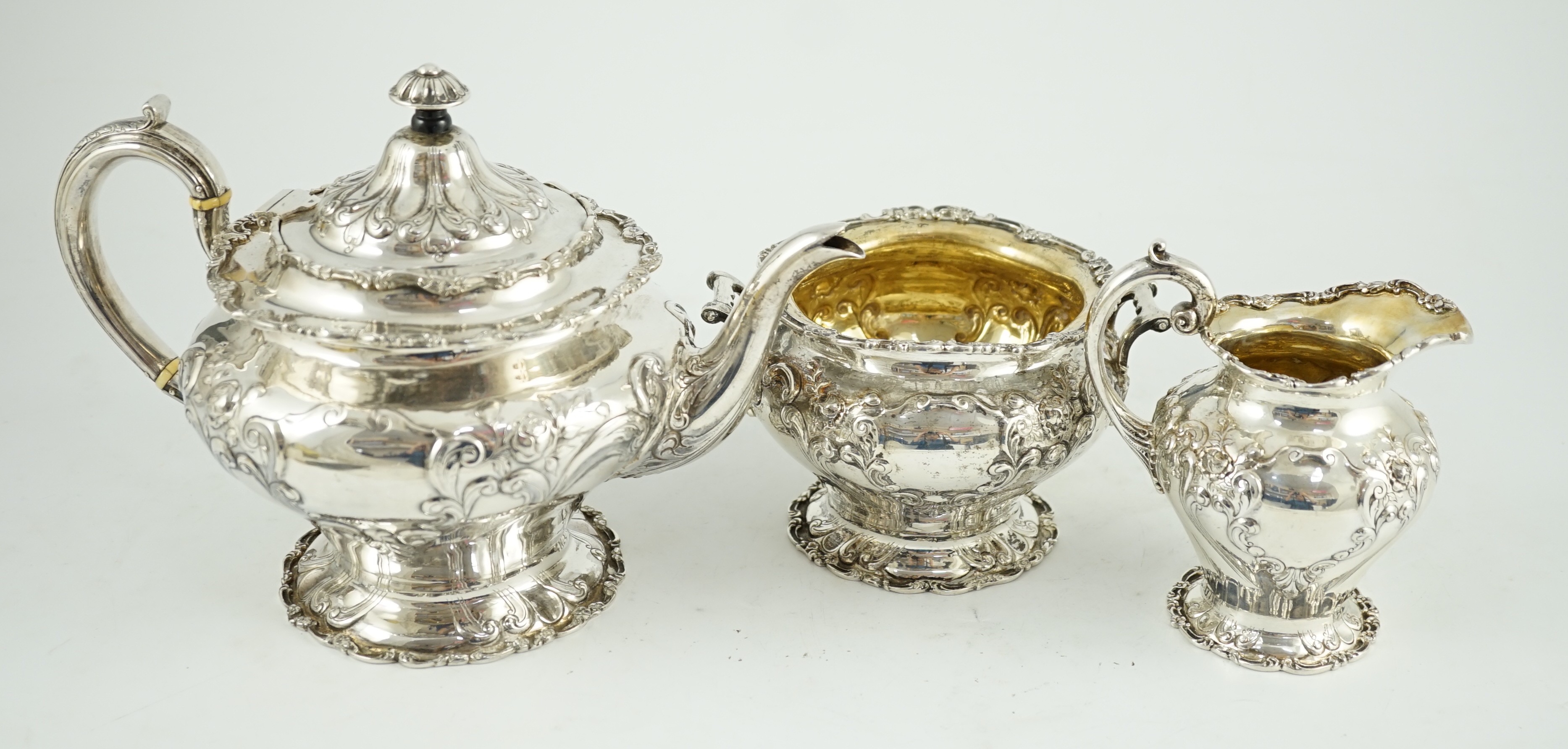 An Edwardian Scottish repousse silver three piece tea set, by Robert Scott